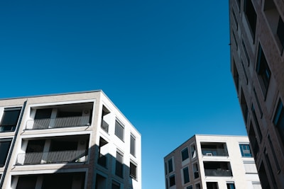 Several modern apartment buildings with multiple floors and balconies are seen against a clear blue sky.