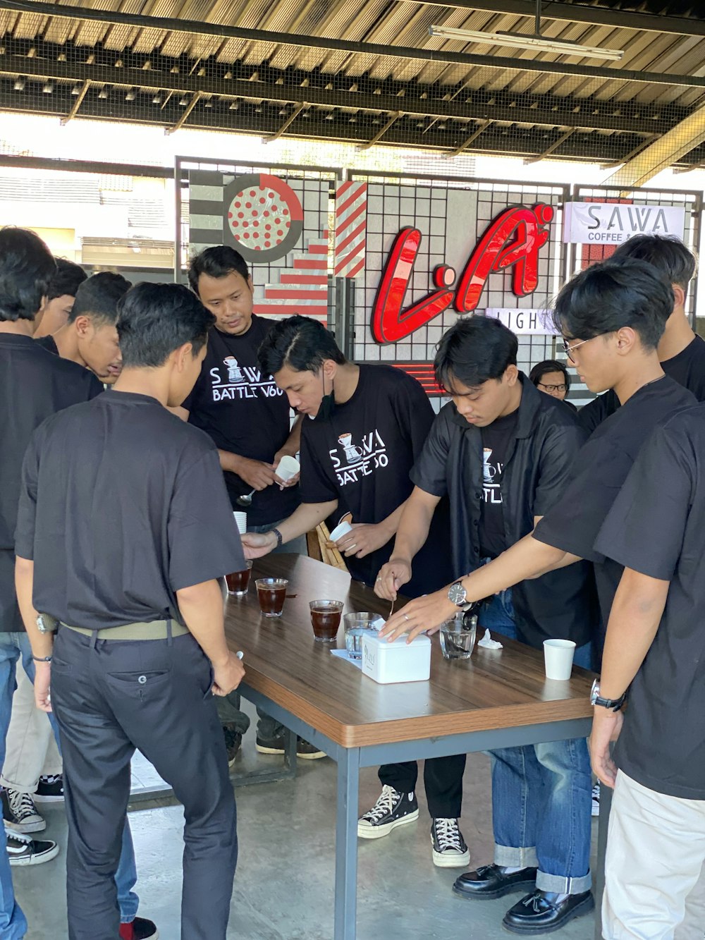 a group of people standing around a table with drinks on it