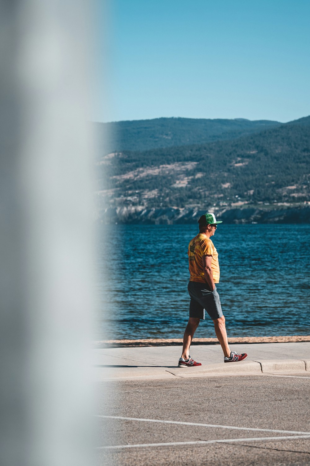 a man standing on a concrete ledge looking at a body of water