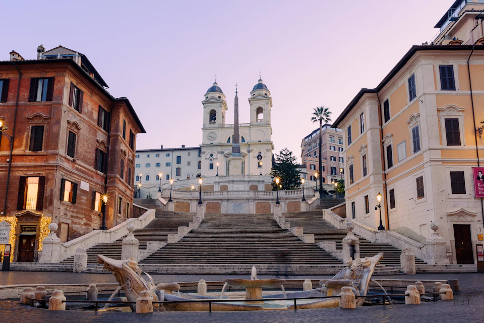 The Spanish Steps at dawn, almost empty, with the Barcaccia fountain in front and Trinità dei Monti above
