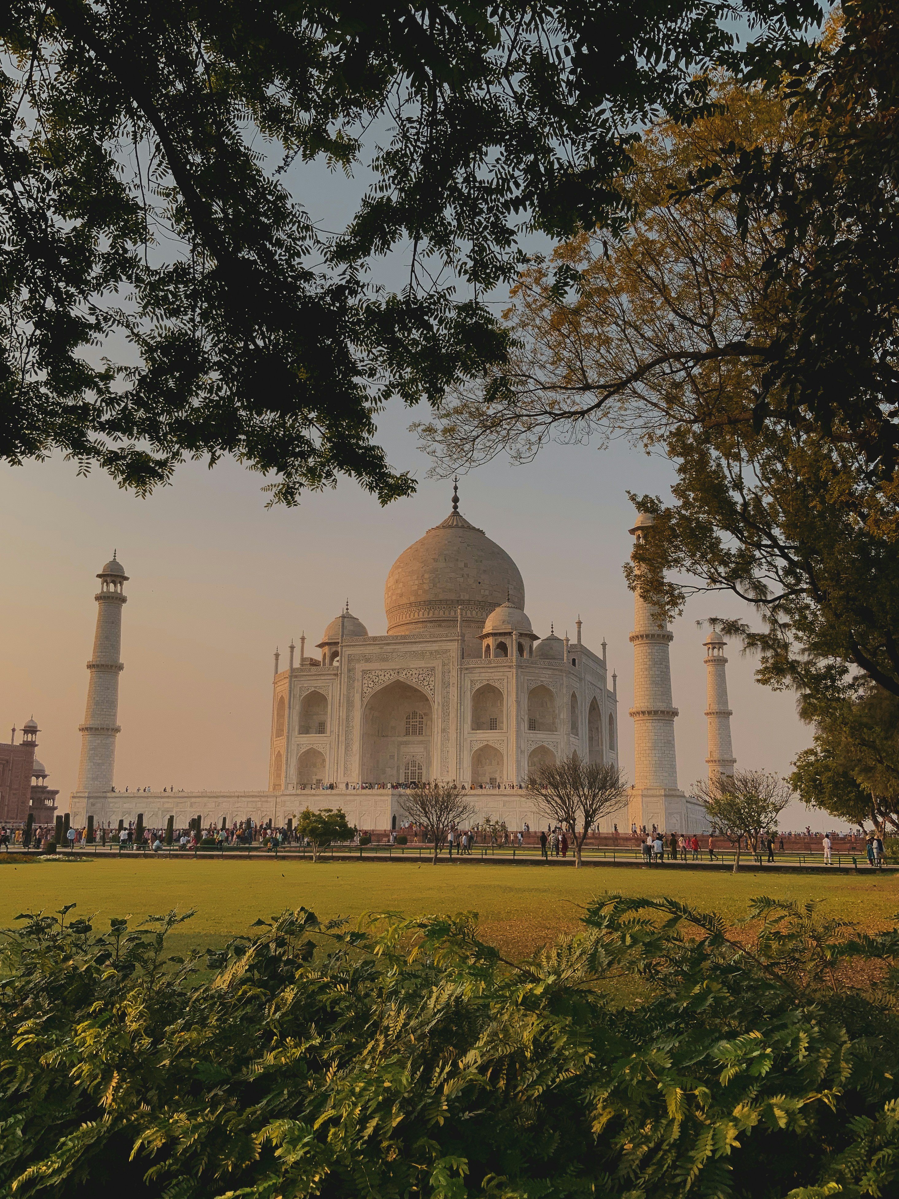 A serene sunrise over the Taj Mahal with soft golden light illuminating the monument.