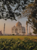 A serene garden view with the Taj Mahal in the background.