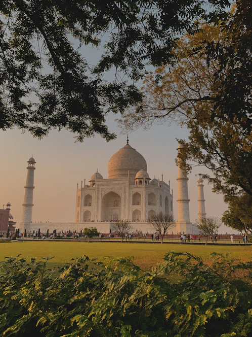 A cinematic view of the Taj Mahal at sunset with a soft dark overlay enhancing the golden hues.