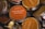 Several round, metal tins with lids featuring labels that have various aromatic scents such as Denmark Hygge and Sicily. The labels are mostly orange and beige with a mix of English and non-English languages detailing the scents.