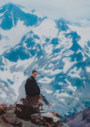 A person outdoors wearing sporty sunglasses with a scenic mountain view behind.
