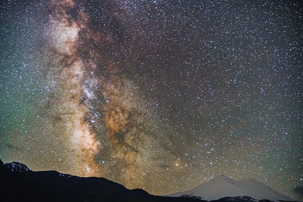 a starry night sky over a mountain range