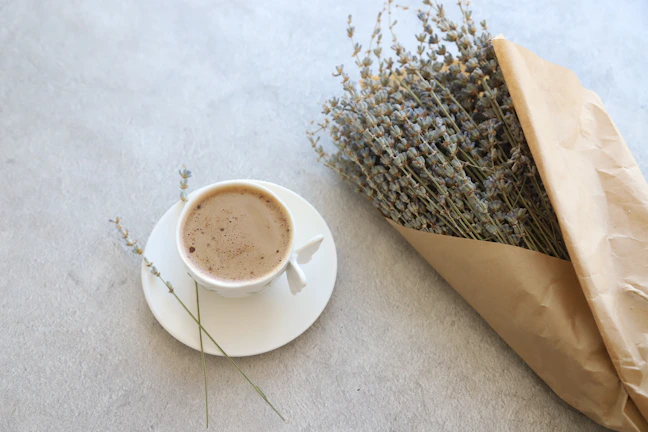 A serene morning scene with a steaming cup of adaptogenic tea beside a minimalist diffuser releasing gentle mist.