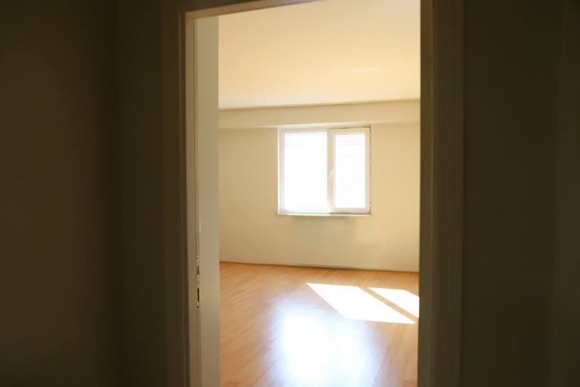 A sparkling clean living room after a move-out cleaning, sunlight streaming through the windows.