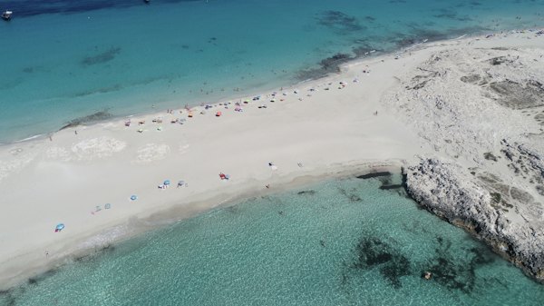 A white-sand beach and shallow turquoise water, from the air — Formentera, Spain
