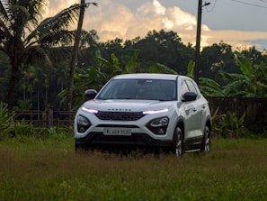 A luxurious SUV parked in front of a tropical resort.