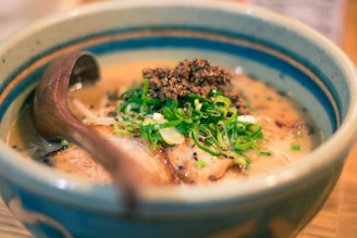 a bowl of soup with meat and broccoli on a plate
