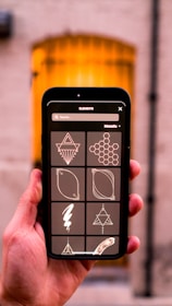 a hand holding a black and yellow electronic device