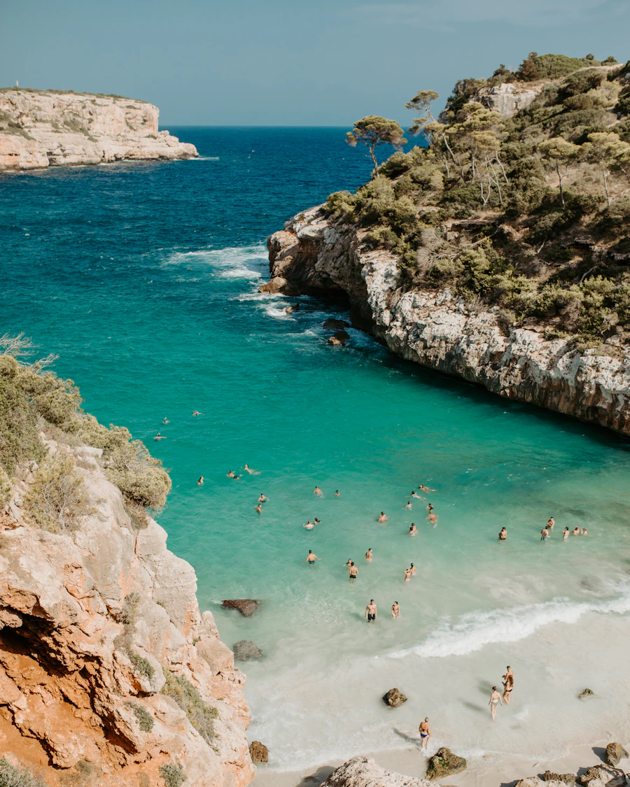 People swimming in clear turquoise water off Mallorca