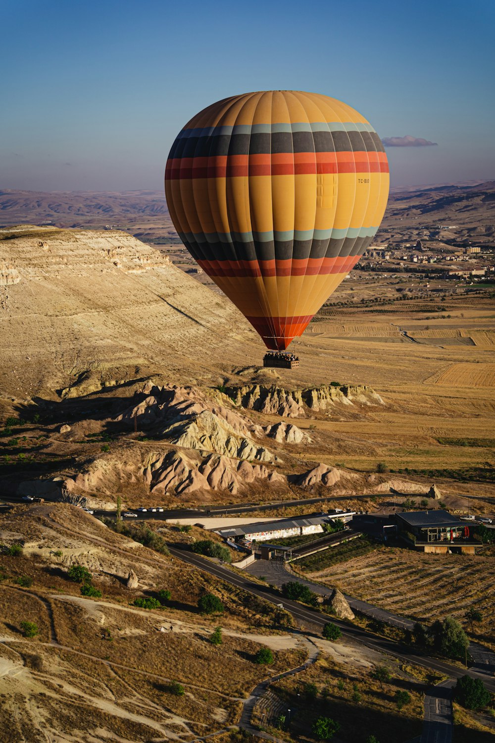 a hot air balloon flying over a valley