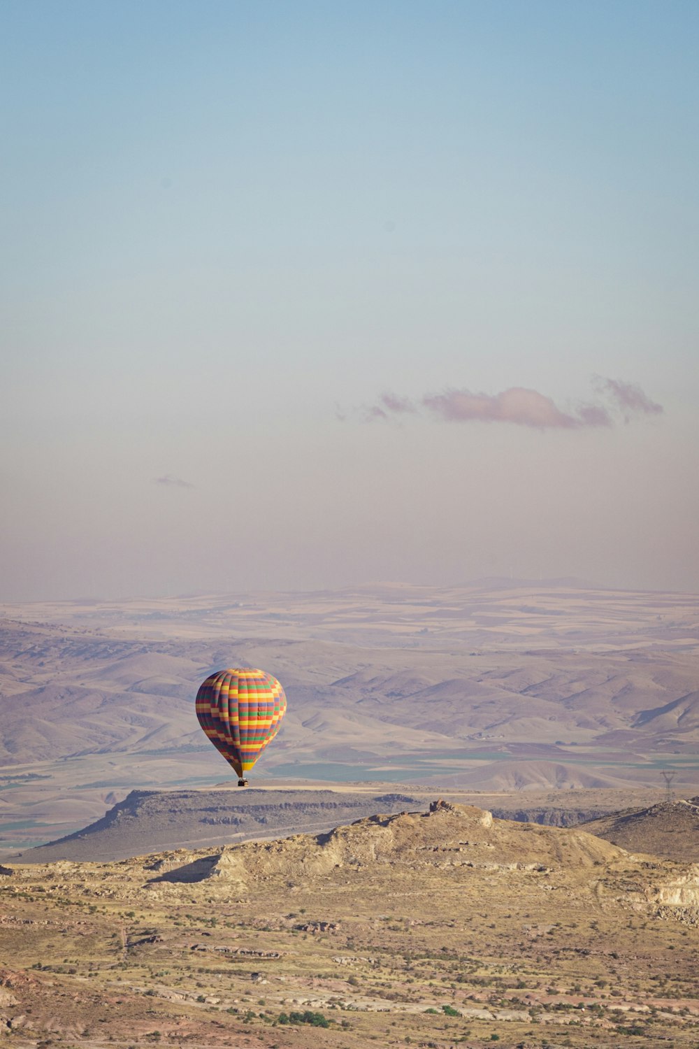 a hot air balloon flying over a desert