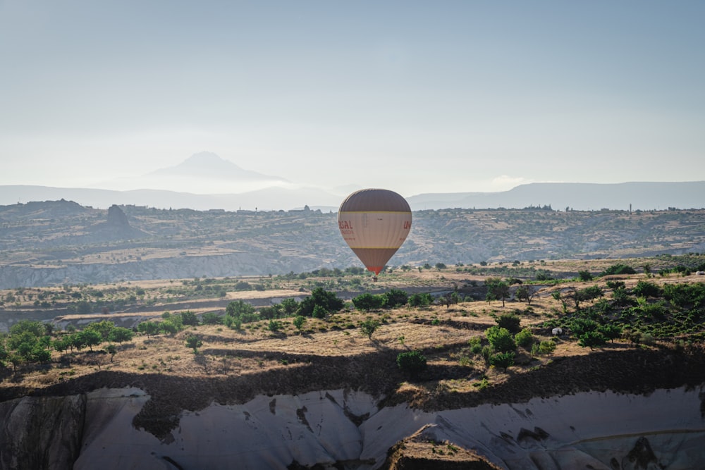 a hot air balloon flying over a desert