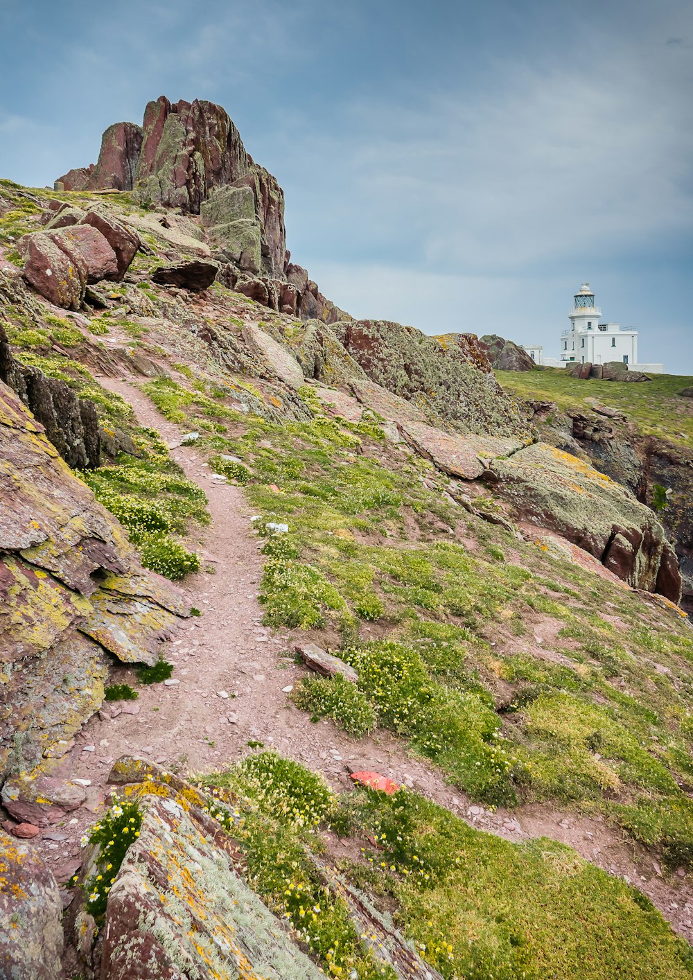 a rocky path with a lighthouse