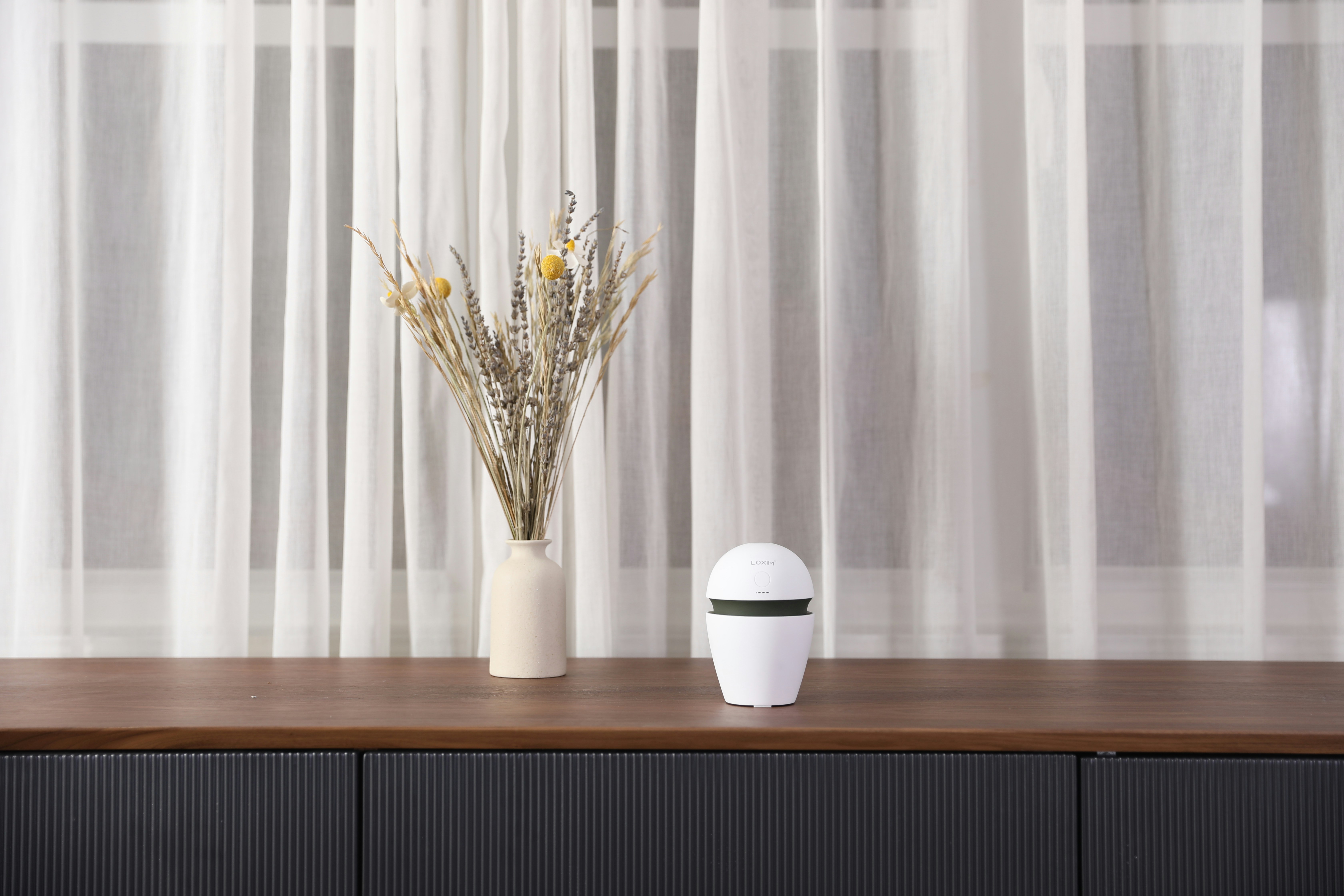 Minimalist modern living room with a sleek smart speaker glowing softly on a wooden table