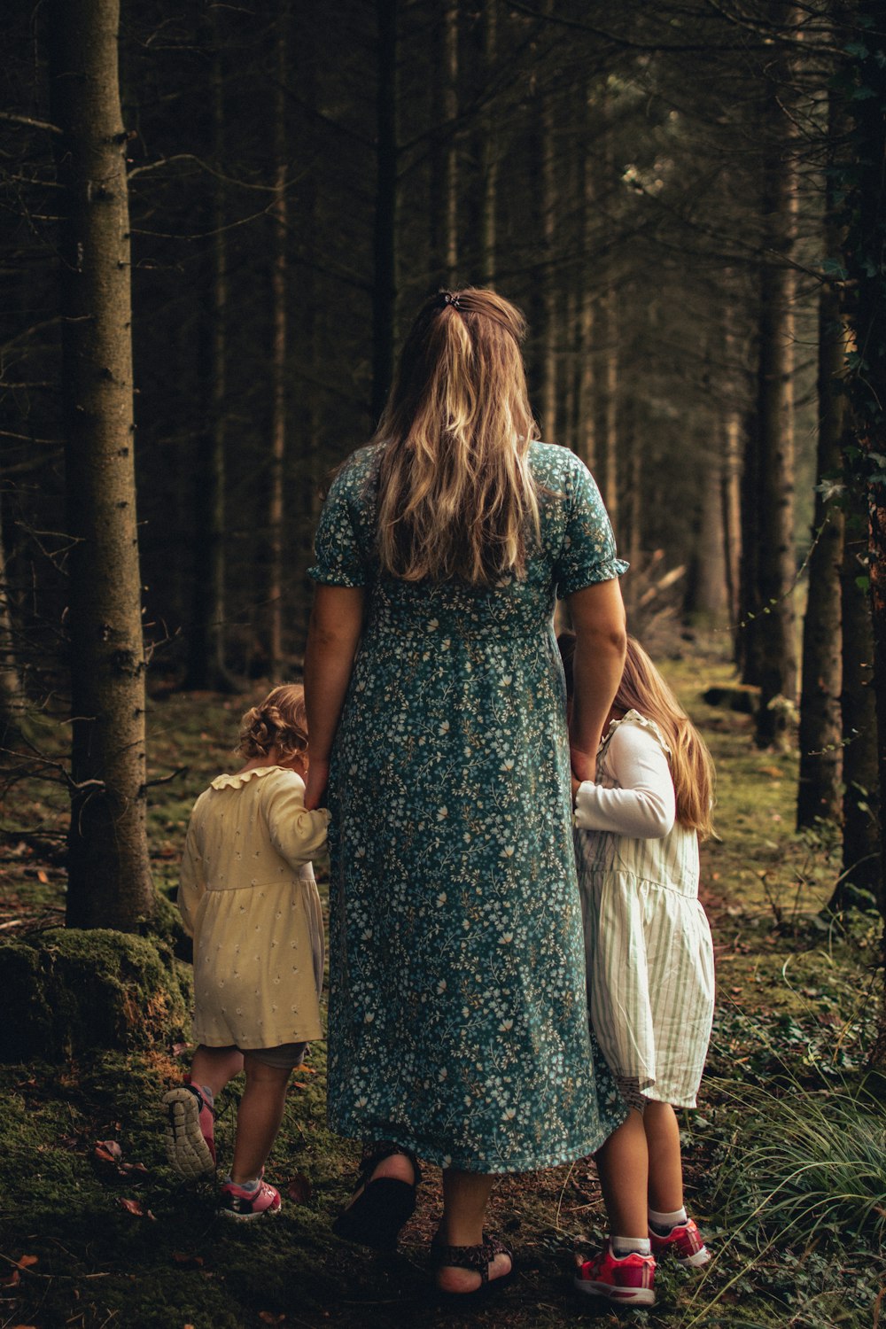 a person and two children in the woods