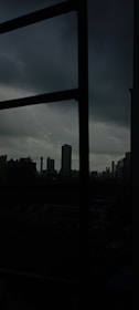 A cinematic frame showing a moody, atmospheric cityscape at night.
