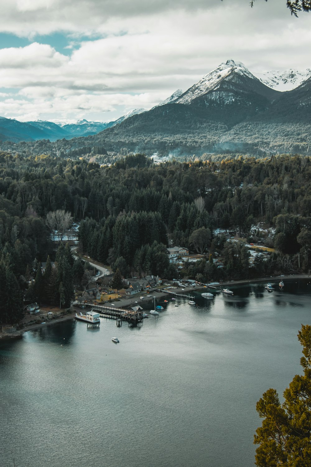 a lake with boats and mountains in the background