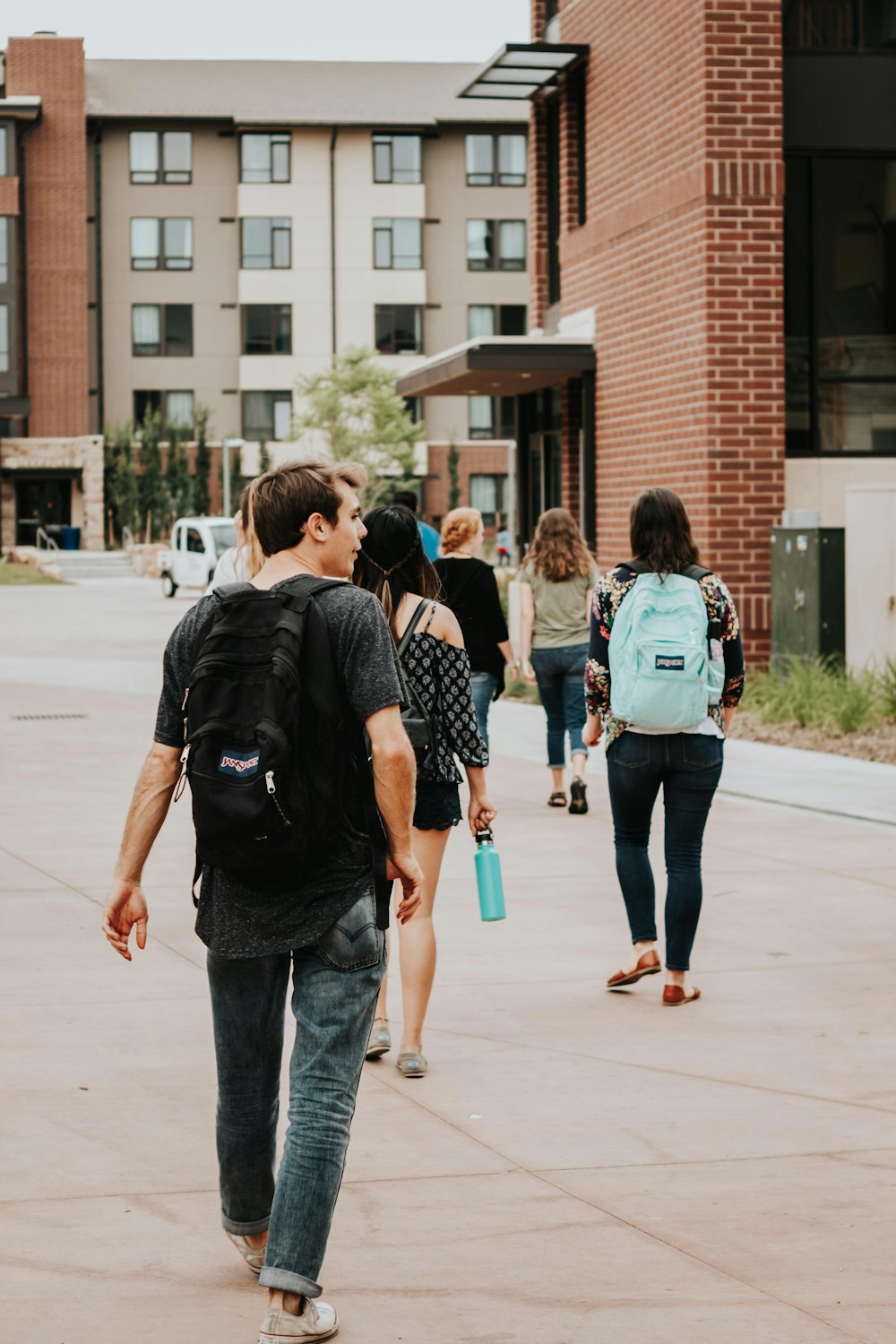 a group of people walking on a sidewalk