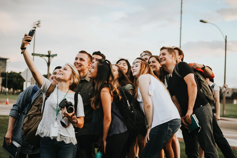 A vibrant group photo of the youth ministry gathered outdoors, smiling and engaged in fellowship.