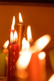 Close-up of colorful handmade decorative candles softly glowing in a cozy room