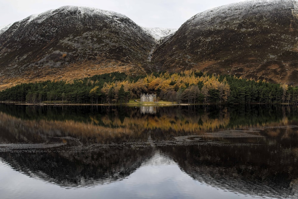 a lake with trees and mountains in the background