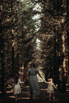 a person and two children walking through a forest