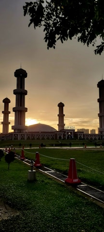 Bright yellow gradient header image of Masjid Muhajirin exterior during sunset