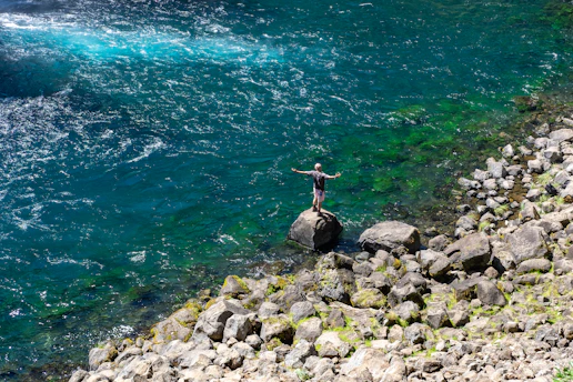 a person standing on a rock in the water