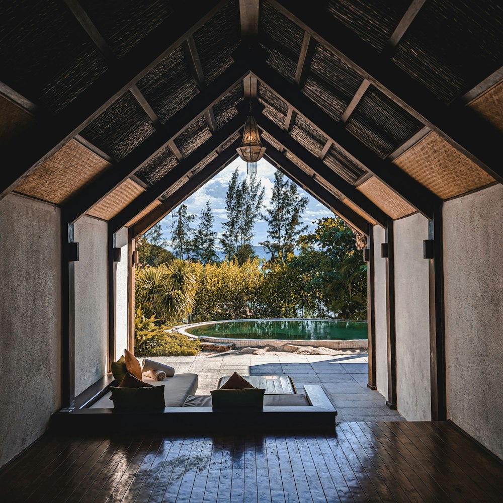 a patio with a table and chairs and a view of trees and a lake