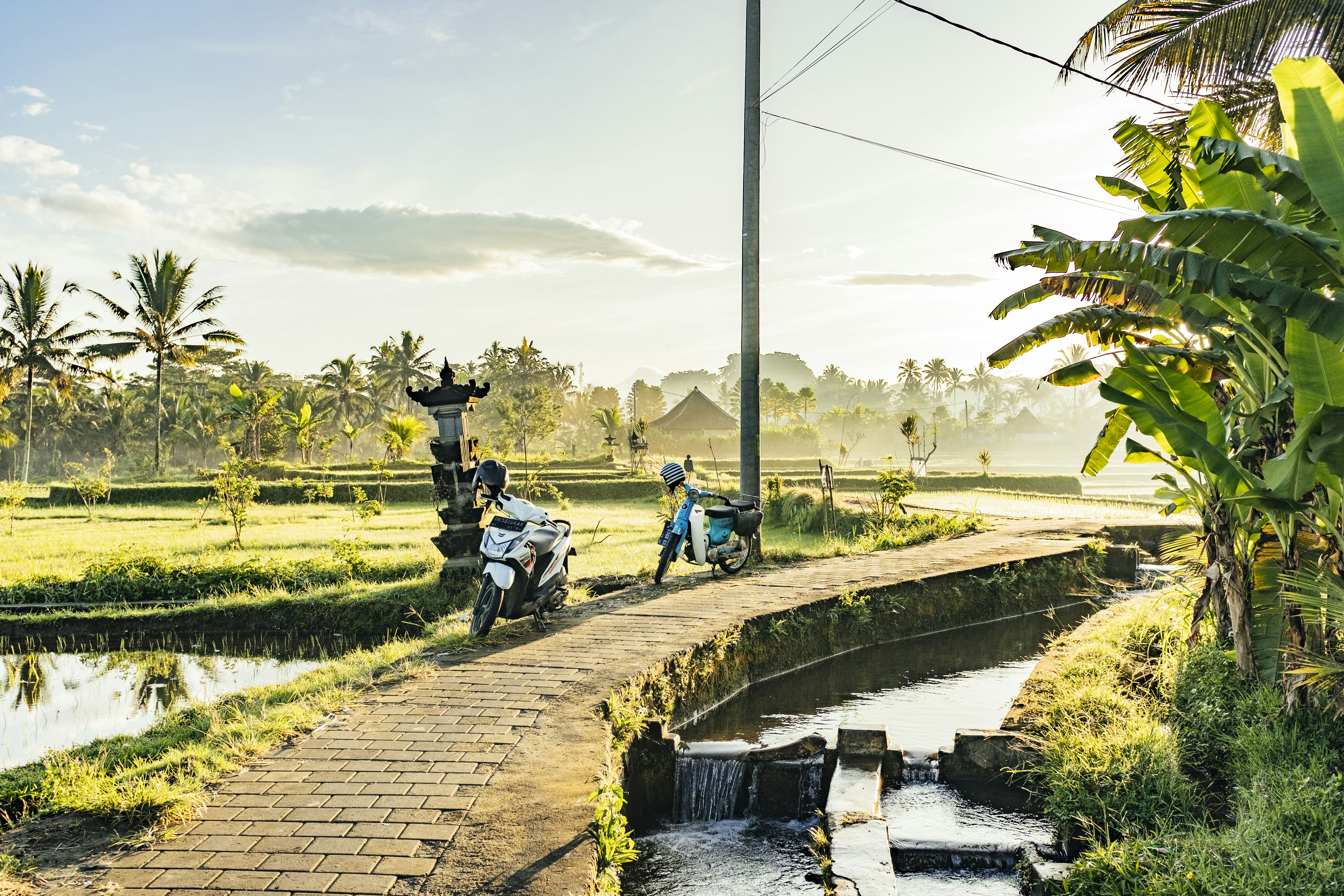 Beberapa sepeda motor di jalan dengan air di samping