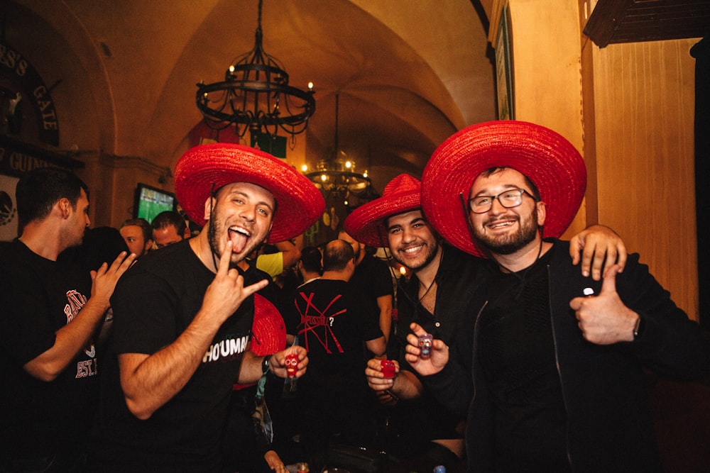 a group of men wearing red hats and holding drinks