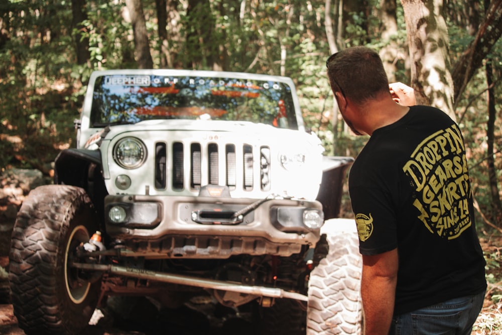 a man standing next to a jeep