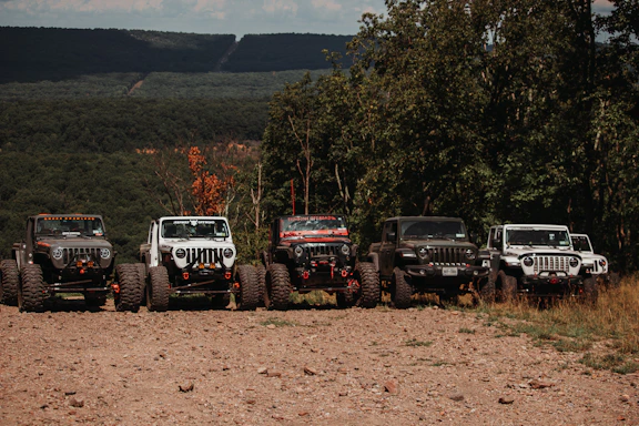 a group of vehicles parked on a dirt road
