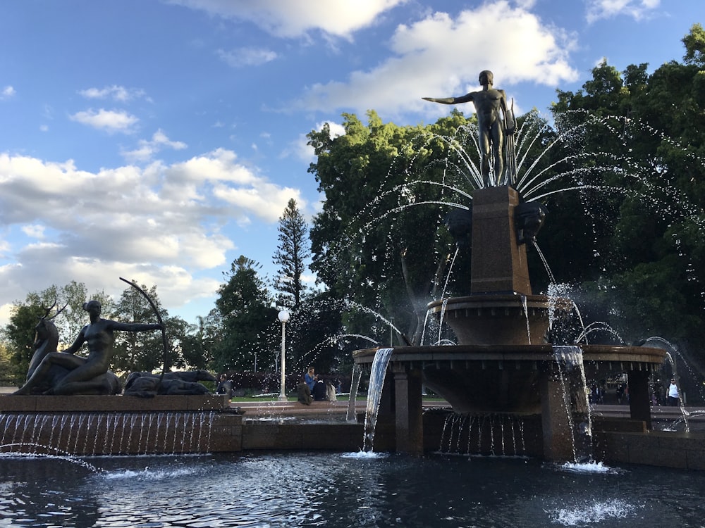 a fountain with statues and trees