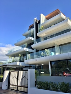 A welcoming modern residential building with landscaped gardens under a bright sky.