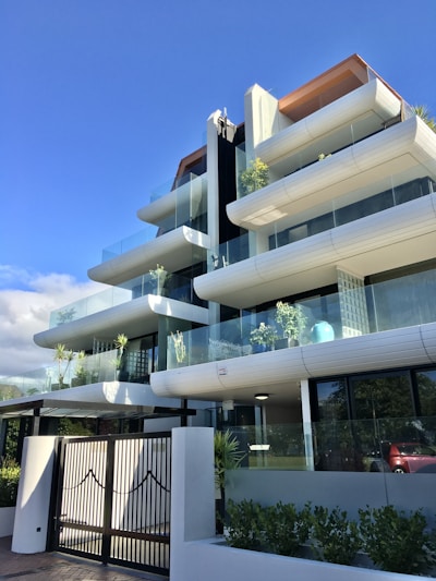 A modern Nigerian residential building showcasing clean lines and vibrant landscaping under a clear blue sky.