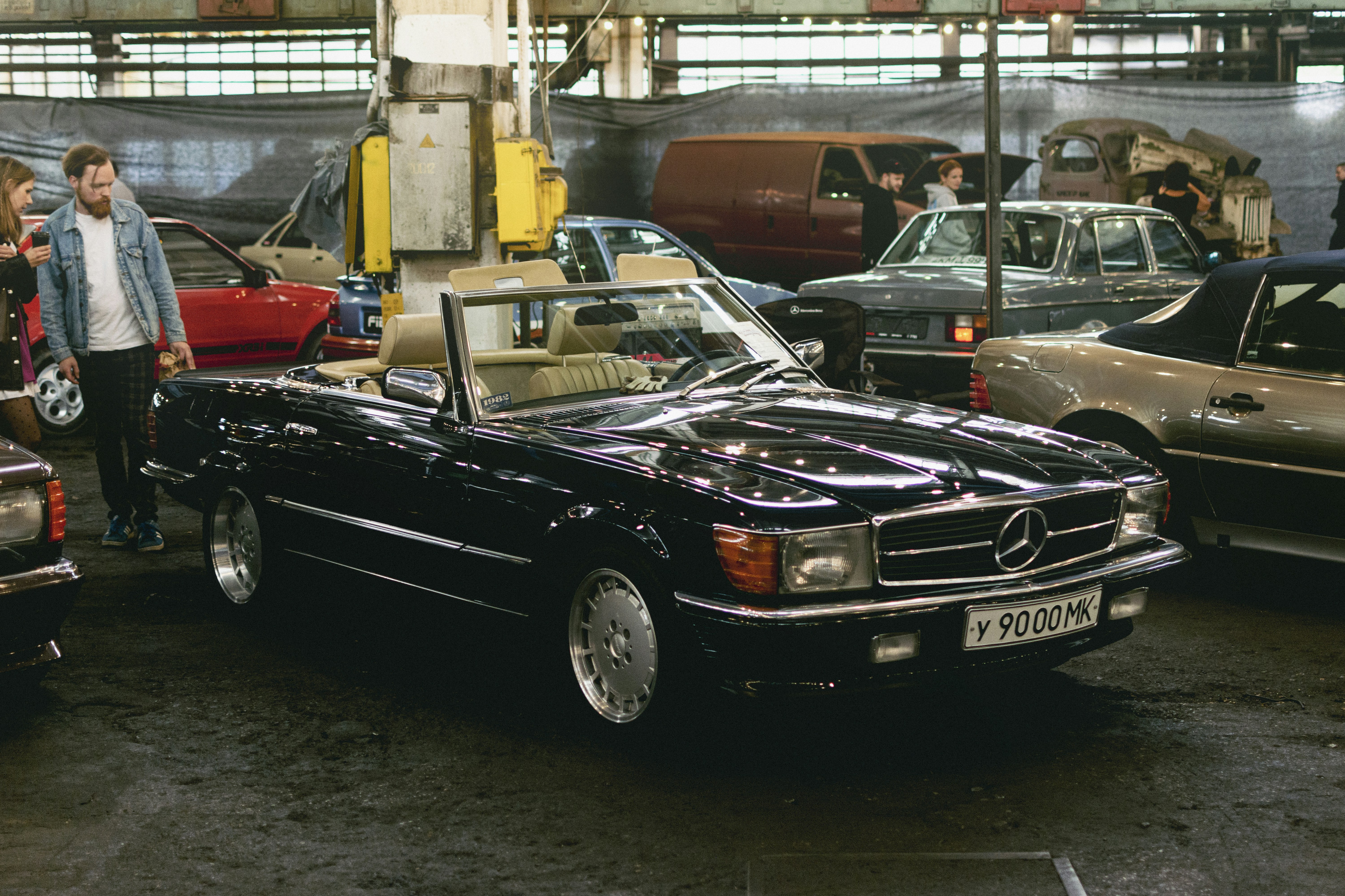 a black car parked in a showroom with other cars
