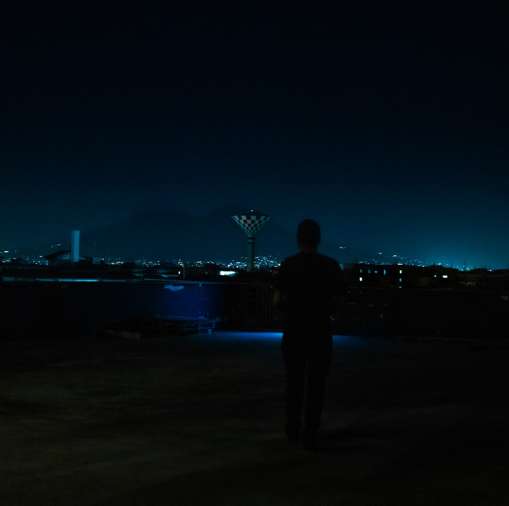 a man standing on a beach at night