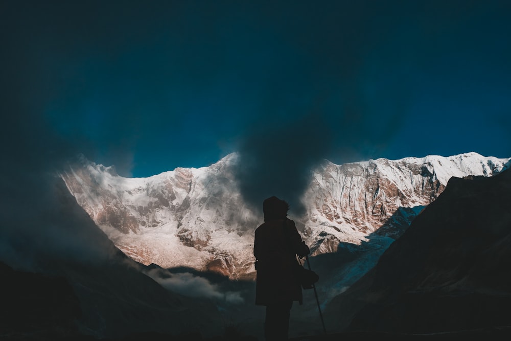 une personne debout au sommet d’une montagne