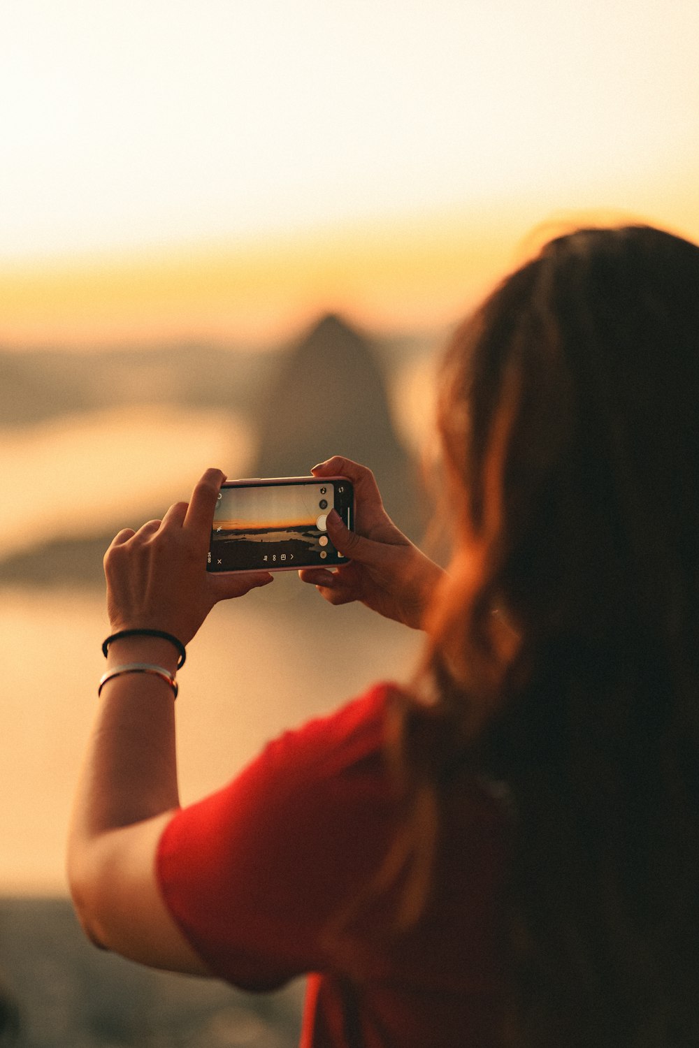 a person taking a picture of a sunset