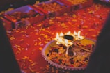 A festive arrangement of rose red and amber aroma jar candles glowing warmly during Diwali.