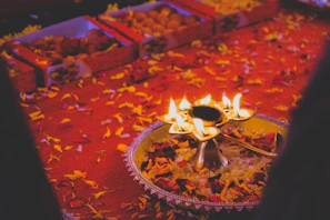 A festive arrangement featuring several brass kalash vessels used during Navratri, with vibrant decorations and diyas.