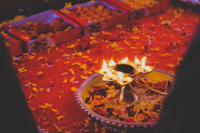 A vibrant display of Diwali-themed corporate gifts with red and black accents, including candles, sweets, and branded items.