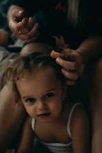 A stylist gently cutting a child's hair with a relaxed and friendly expression.
