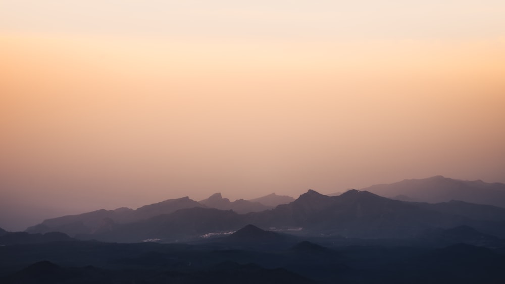 a landscape with hills and a sunset