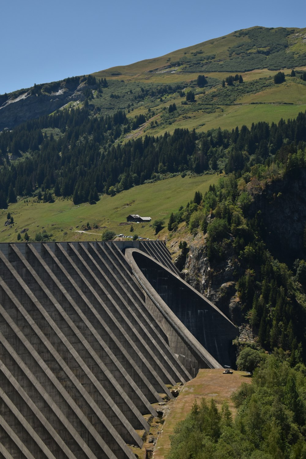 a large dam with a house in the background
